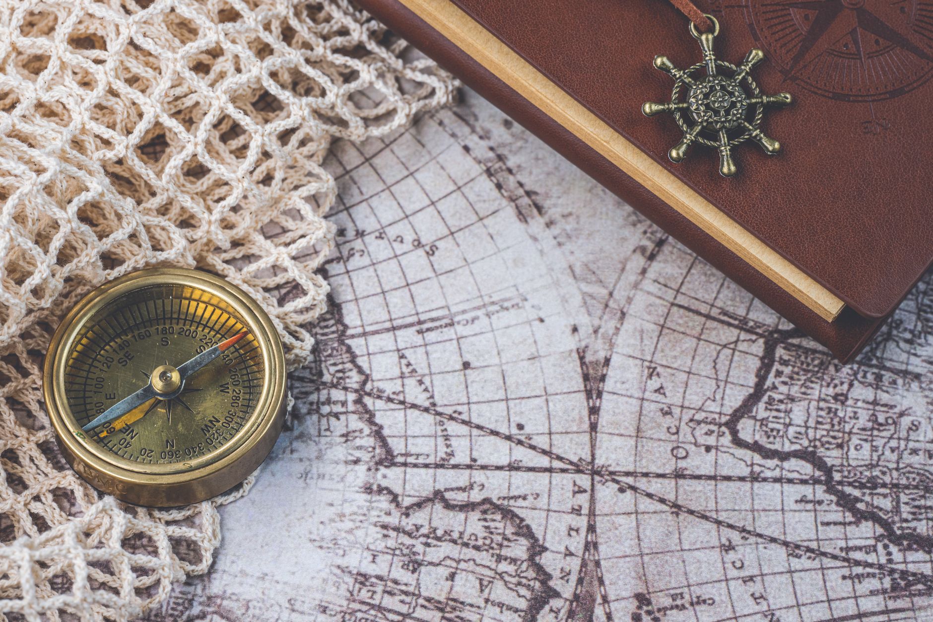 Carefully mapped travel itinerary notebooks and antique brass compass